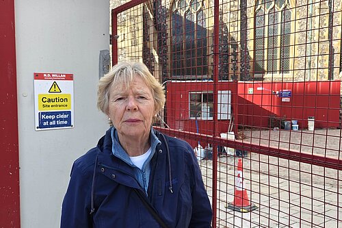 Cllr Judith Lubbock in front of the building site at the Halls. 