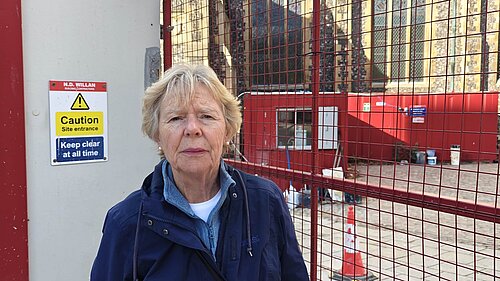 Cllr Judith Lubbock in front of the building site at the Halls. 